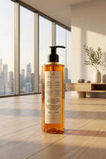 A bottle of PRIJA Vitalizing Shower gel and shampoo with a black pump dispenser, filled with amber-colored liquid, on a white background.